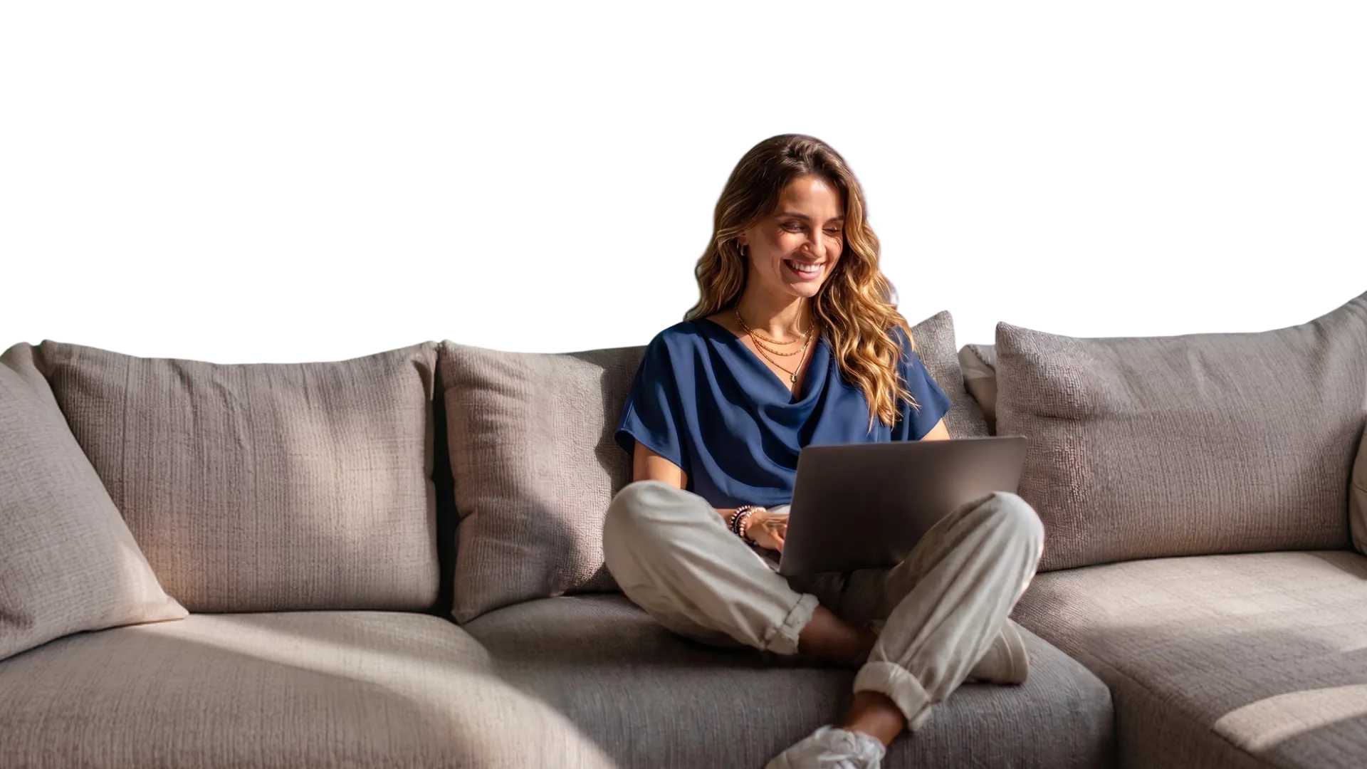 Mulher sorrindo usando o notebook no sofá